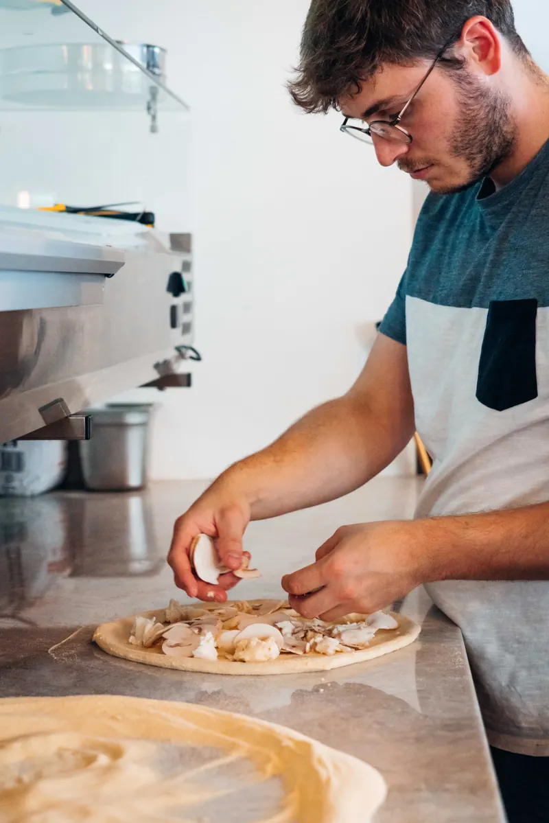 Le pizzaiolo du Botza prépare une pizza devant le four