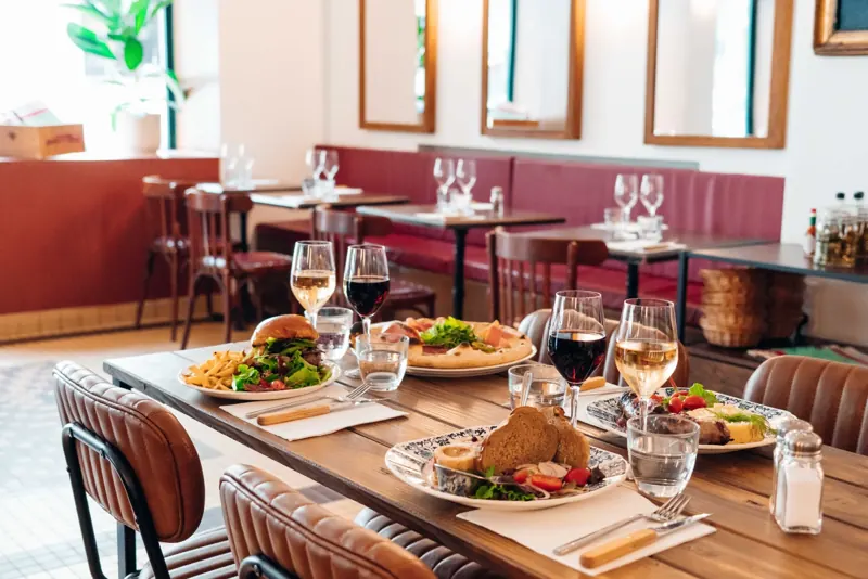 La salle du bistrot Botza avec ses tables dressées, banquettes et miroirs